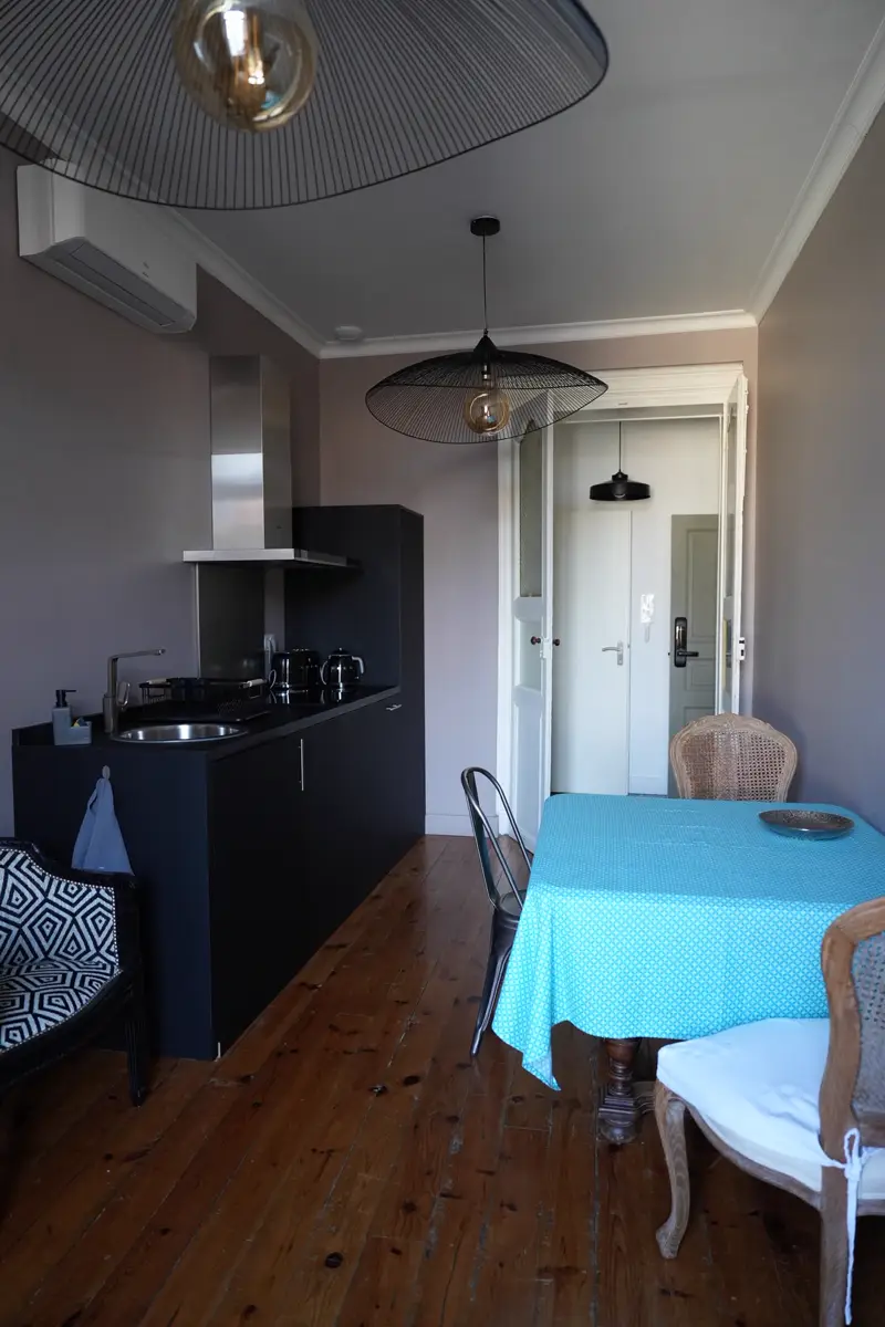 Cuisine équipée de l'appartement Apollon ouverte sur la salle à manger, parquet ancien