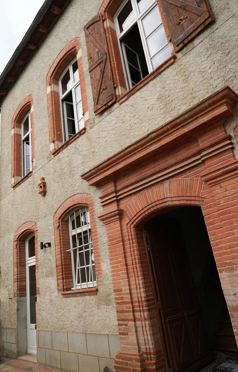 Façade en brique rose et pierre de la Maison du Soleil, place Gambetta à L'Isle-Jourdain