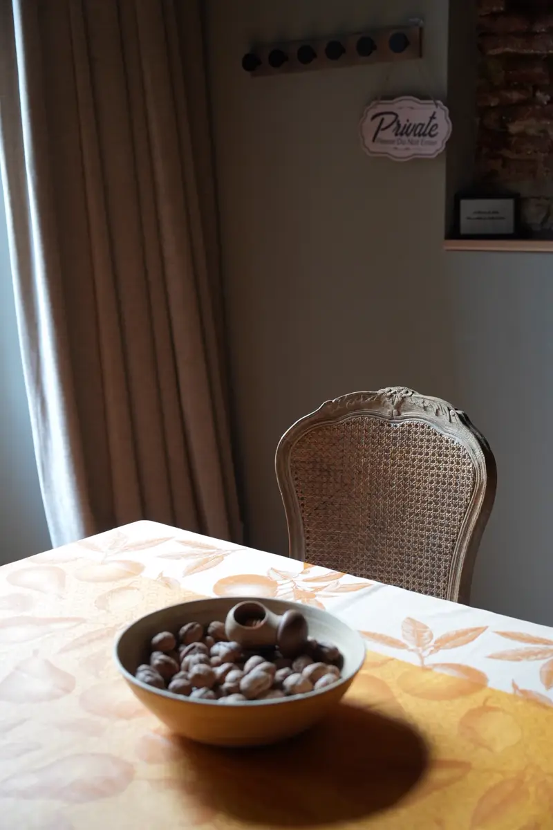 Coupe de noix sur la nappe provençale, près du rideau de lin et d'une chaise cannée
