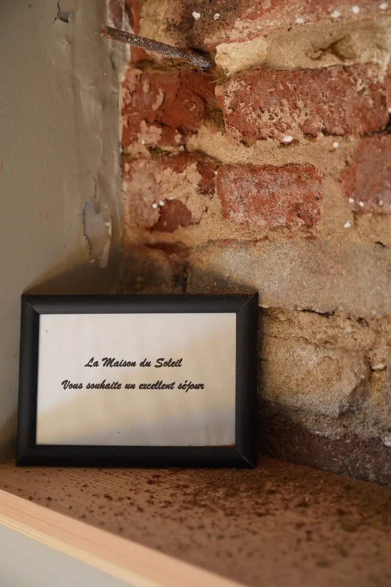 Cadre posé sur une étagère : « La Maison du Soleil vous souhaite un excellent séjour »
